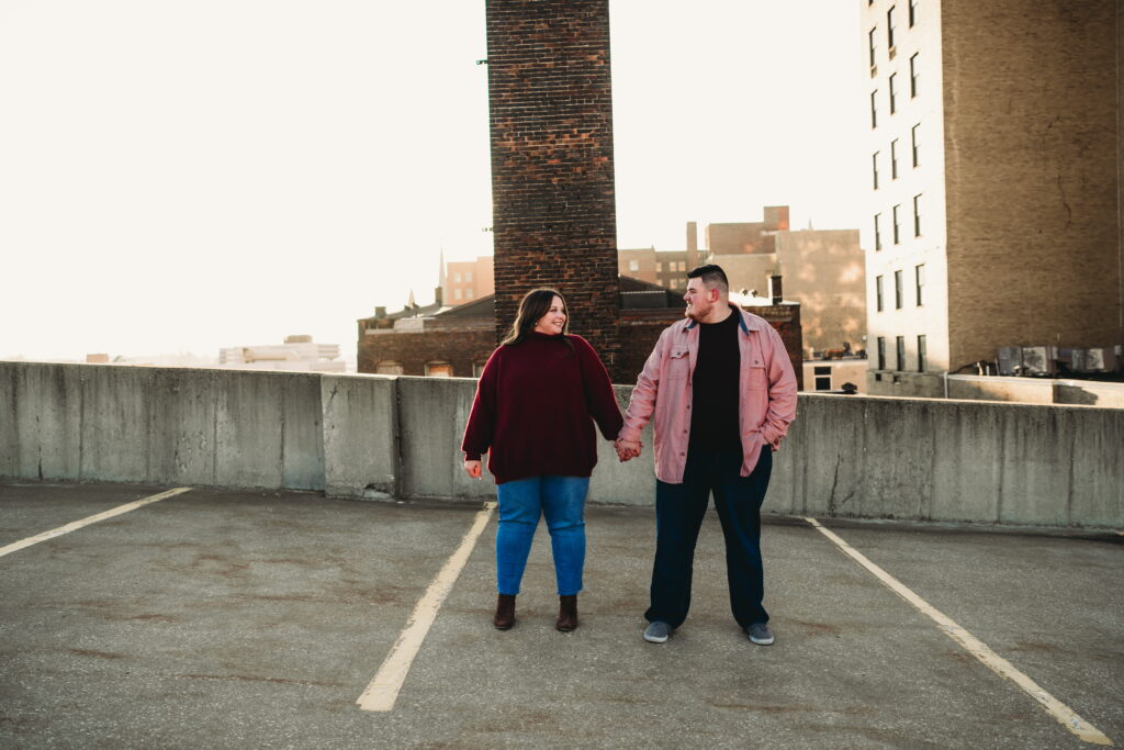 Capturing Love and Emotion: Moody and Romantic Engagement Portraits in Downtown Erie and Pittsburgh, PA by Rylee Louisa Photography. Specializing in Candid Moments on Rooftop Parking Garages, this Wedding and Couples Photographer beautifully portrays the Emotional Essence of Love in Urban Landscapes.