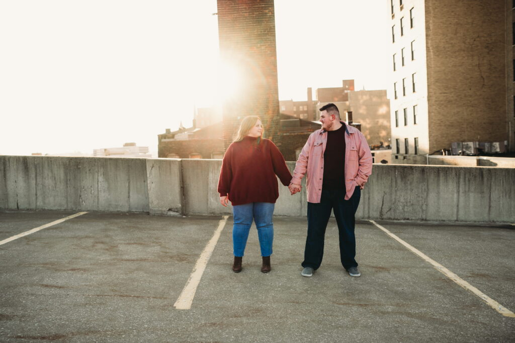 Capturing Love and Emotion: Moody and Romantic Engagement Portraits in Downtown Erie and Pittsburgh, PA by Rylee Louisa Photography. Specializing in Candid Moments on Rooftop Parking Garages, this Wedding and Couples Photographer beautifully portrays the Emotional Essence of Love in Urban Landscapes.
