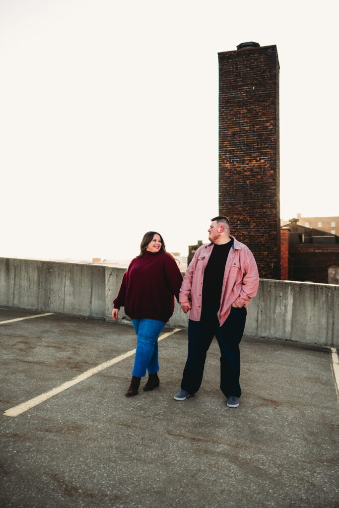 Capturing Love and Emotion: Moody and Romantic Engagement Portraits in Downtown Erie and Pittsburgh, PA by Rylee Louisa Photography. Specializing in Candid Moments on Rooftop Parking Garages, this Wedding and Couples Photographer beautifully portrays the Emotional Essence of Love in Urban Landscapes.