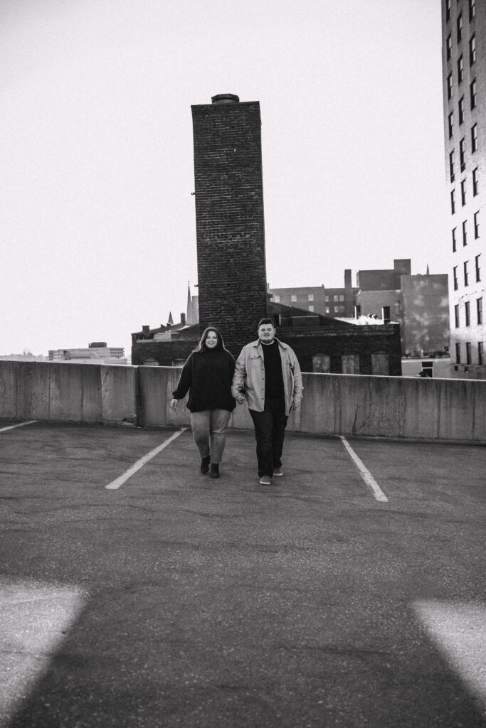 Capturing Love and Emotion: Moody and Romantic Engagement Portraits in Downtown Erie and Pittsburgh, PA by Rylee Louisa Photography. Specializing in Candid Moments on Rooftop Parking Garages, this Wedding and Couples Photographer beautifully portrays the Emotional Essence of Love in Urban Landscapes.