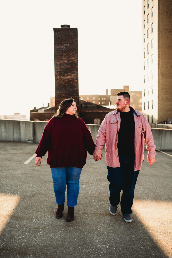 Capturing Love and Emotion: Moody and Romantic Engagement Portraits in Downtown Erie and Pittsburgh, PA by Rylee Louisa Photography. Specializing in Candid Moments on Rooftop Parking Garages, this Wedding and Couples Photographer beautifully portrays the Emotional Essence of Love in Urban Landscapes.