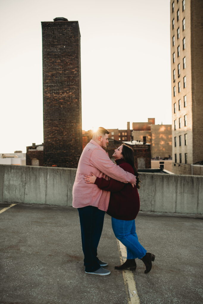 Capturing Love and Emotion: Moody and Romantic Engagement Portraits in Downtown Erie and Pittsburgh, PA by Rylee Louisa Photography. Specializing in Candid Moments on Rooftop Parking Garages, this Wedding and Couples Photographer beautifully portrays the Emotional Essence of Love in Urban Landscapes.