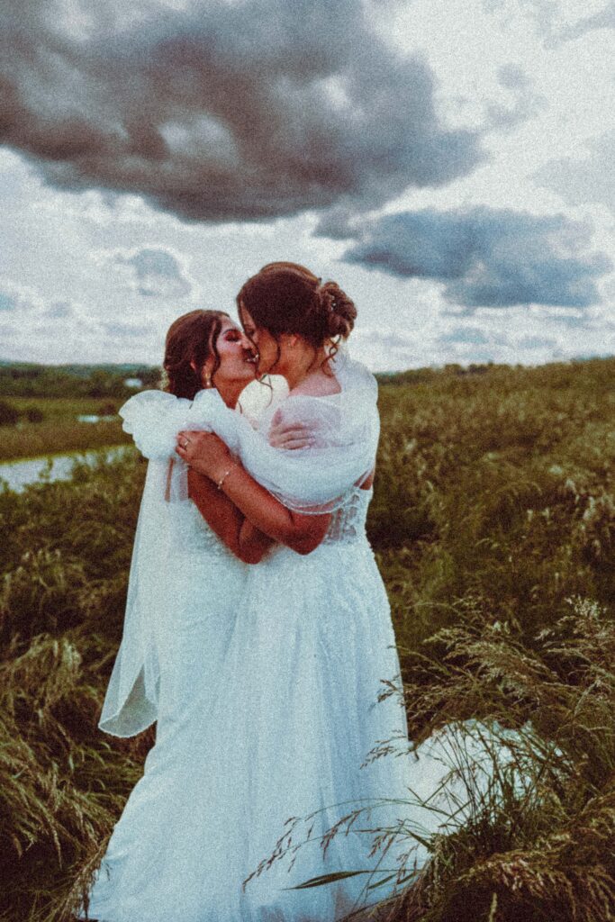 Close-up of two women in wedding dresses embracing, intimate lesbian wedding photography in Pennsylvania