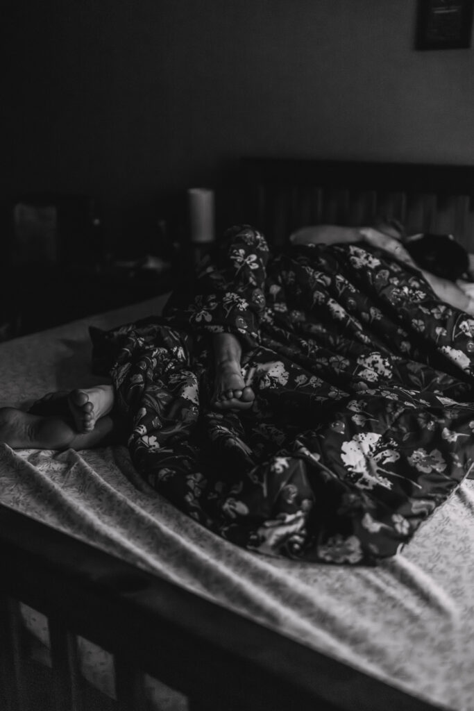 Queer couple cuddling together in bed on their wedding morning, intimate documentary wedding photography moment