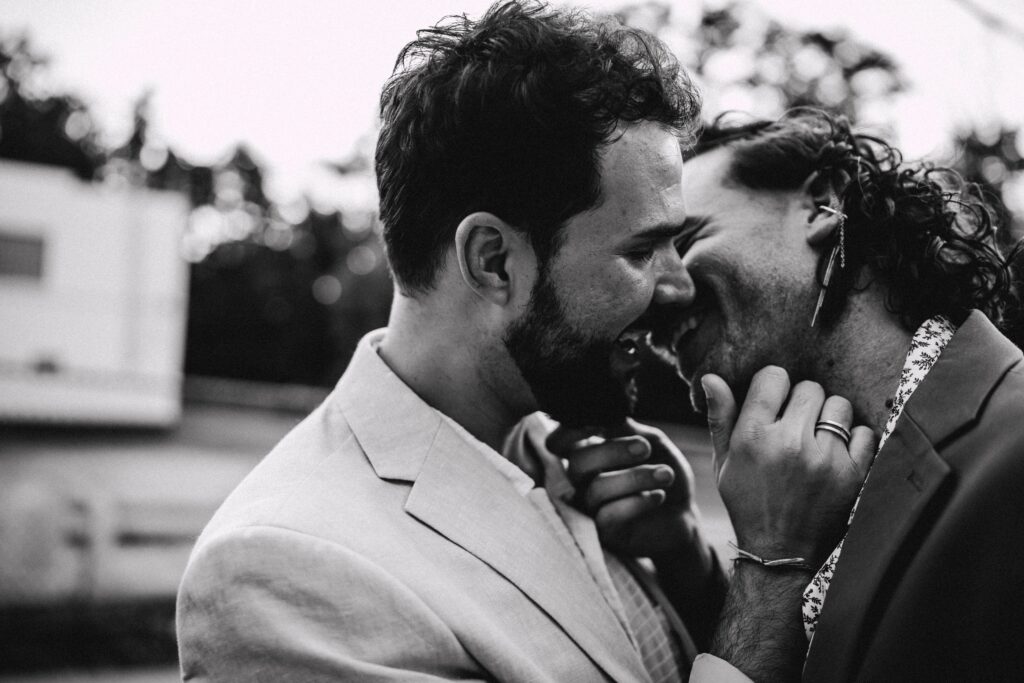 Two grooms kissing during golden hour, captured by queer wedding photographer team in Pittsburgh